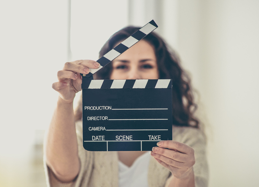 Attractive young woman holds an open film slate